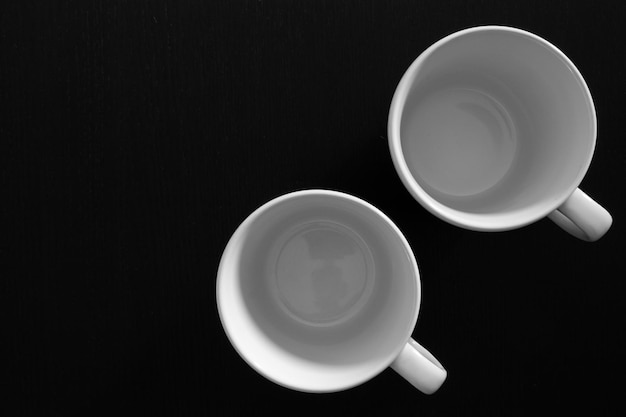 Empty white cups on black wooden table Kitchen tools close up