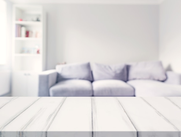 An empty white desk in front of blur sofa in the living room