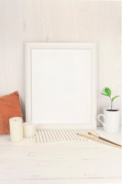 Empty white frame mockup with small branch of succulent zamioculcas in a vintage vase mug