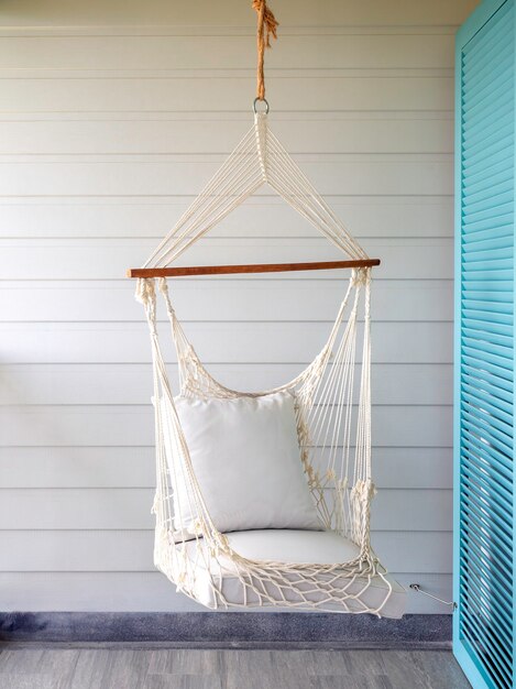 Empty white knitting rope swing hanging from ceiling