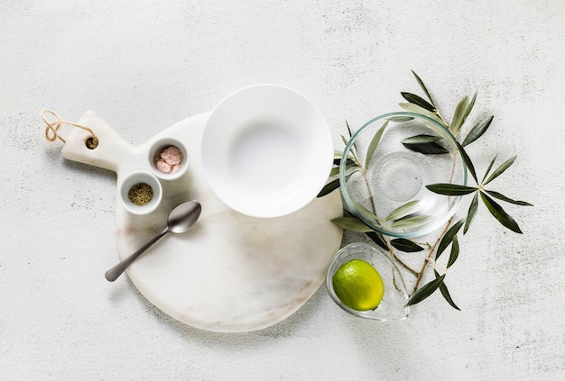 Empty white marble cutting board and olive tree branch