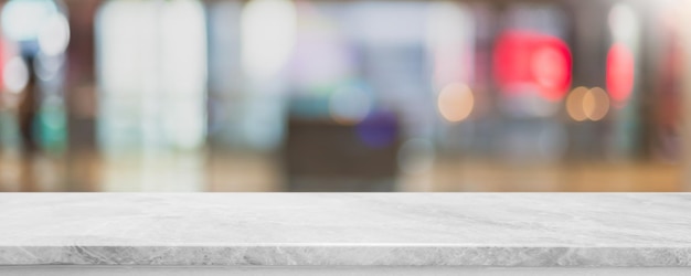 Photo empty white marble stone table top and blur glass window interior cafe and restaurant banner mock up abstract background can used for display or montage your products