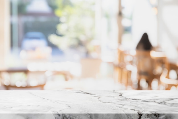 空の白い大理石の石のテーブルの上にボケ味のカフェの背景をぼかした写真。