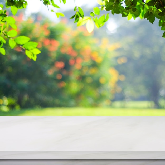 Empty white marble table over blur green park background