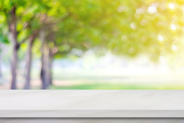 Empty white marble table over blur green park nature background, display montage