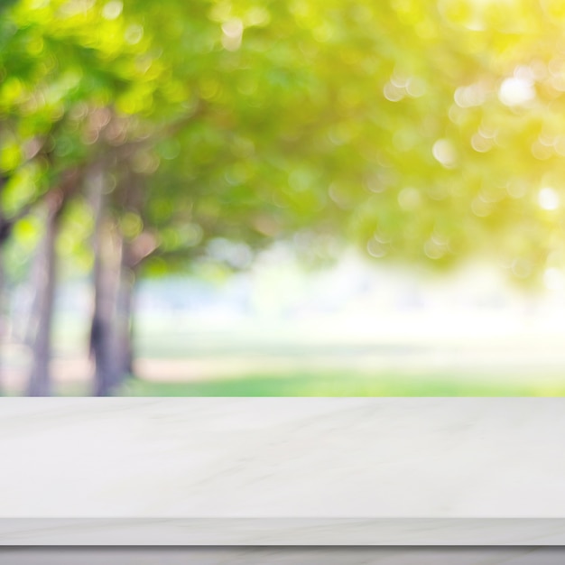 Empty white marble table over blur green park nature background, display montage