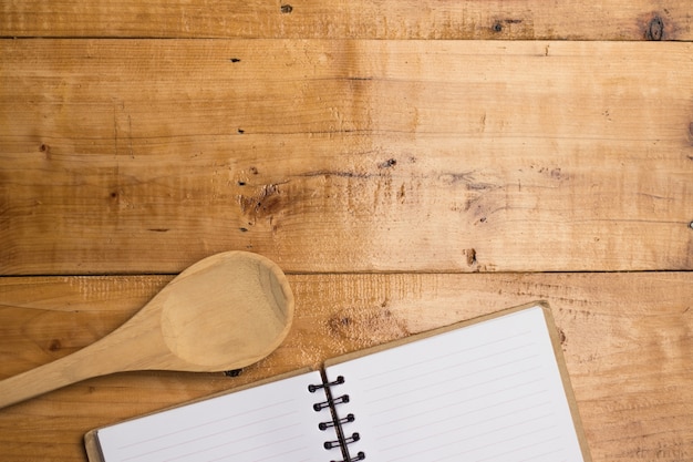 Empty white paper of book and spoon on blank wooden