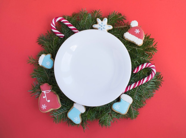 Empty white plate and Christmas composition on the red background Top view Copy space