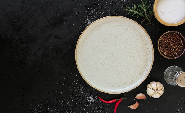 Empty white plate on a dark metal background. Top view with copy space.