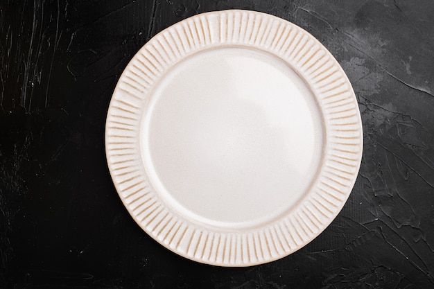 Empty white plate porcelain set with copy space for text or food with copy space for text or food, top view flat lay, on black dark stone table background