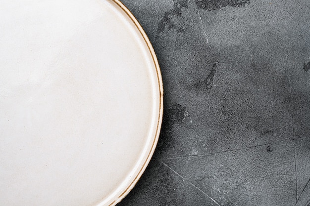 Empty white plate porcelain set with copy space for text or food with copy space for text or food, top view flat lay, on gray stone table background