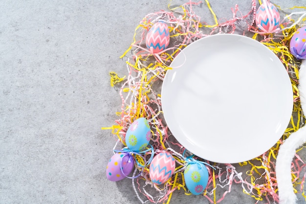 Empty white plate on the table decorated in Easter theme.