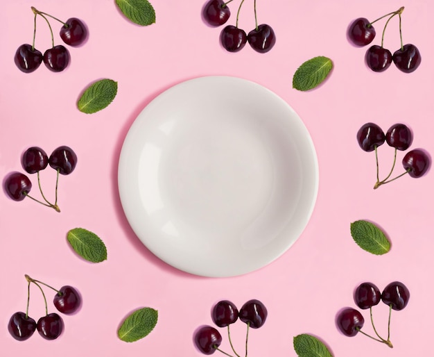 Пустая белая тарелка для текста вишня и мята на розовом фоне Копировать пространство Верхний вид