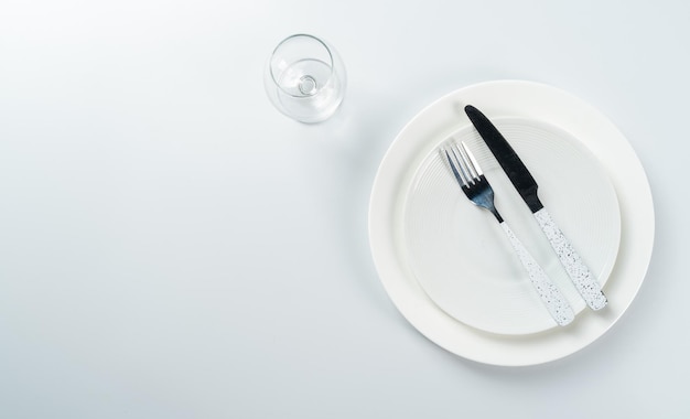 Фото Пустая белая тарелка с белой современной ложкой на белом фоне, макет сверху