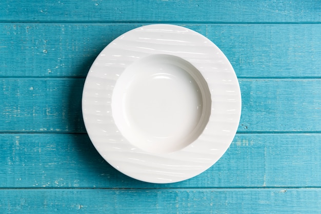 Empty white plate on wooden background, Top view