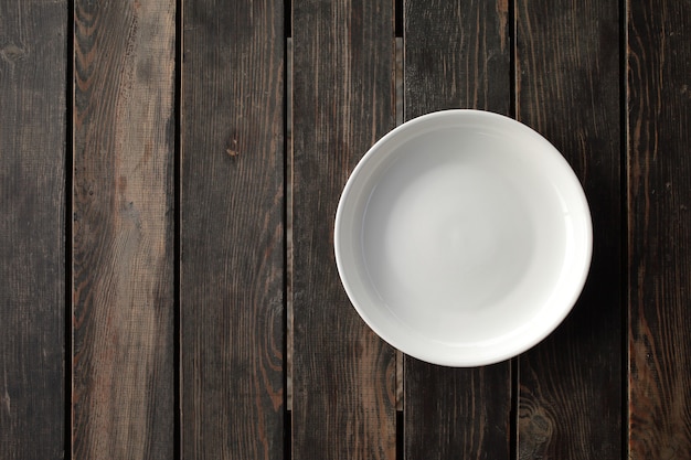 Empty white plate on a wooden loft table