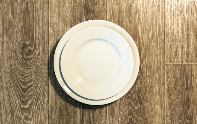 Empty white plate on wooden table