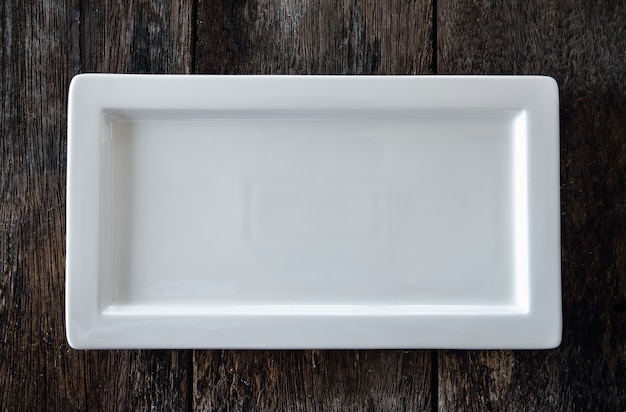 Empty white plate on wooden