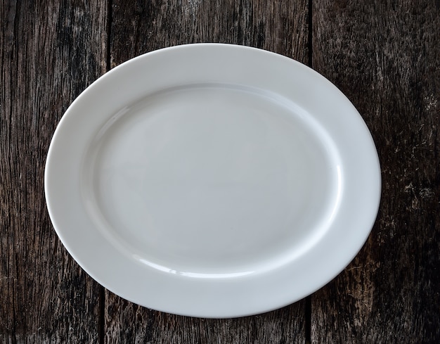 Empty white plate on wooden