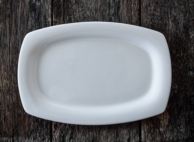 Empty white plate on wooden