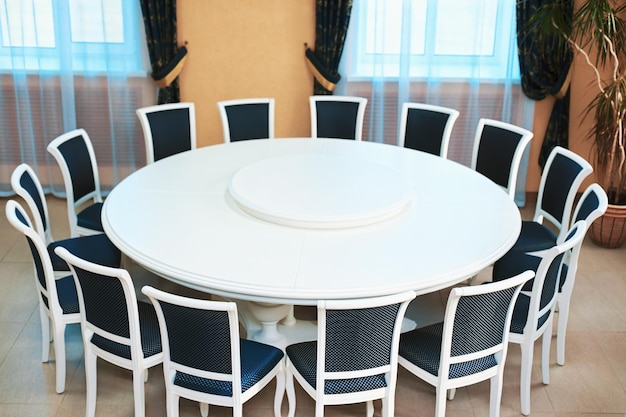 Empty white round conference table and chairs diplomatic\
background