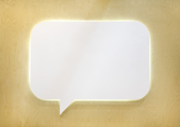 Empty white speech bubble on wooden wall.