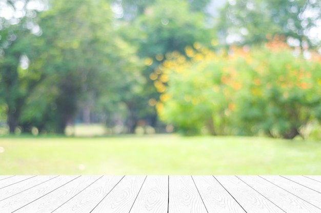 Photo empty white table, perspective wood over blur trees with bokeh background, product display montage background