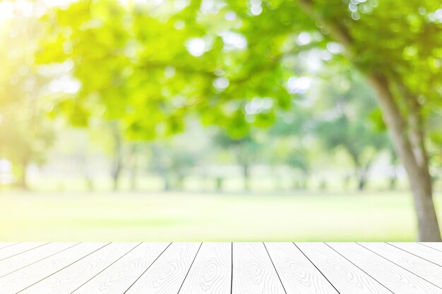 Photo empty white table, perspective wood over blur trees with bokeh background