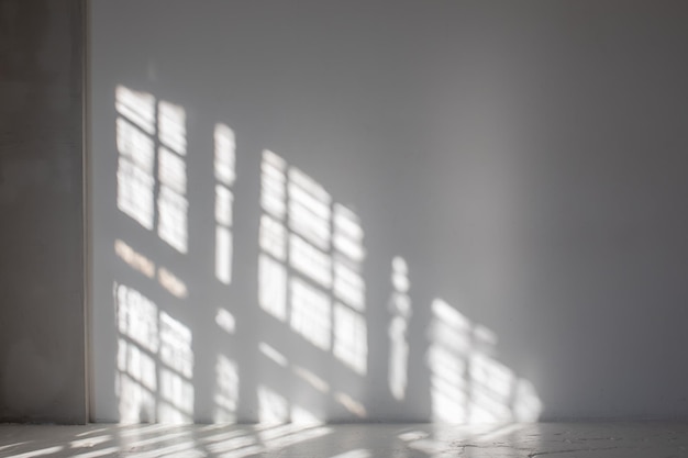 Empty white wall where sunlight shining through a window concept of sunbeams to overlay a photo