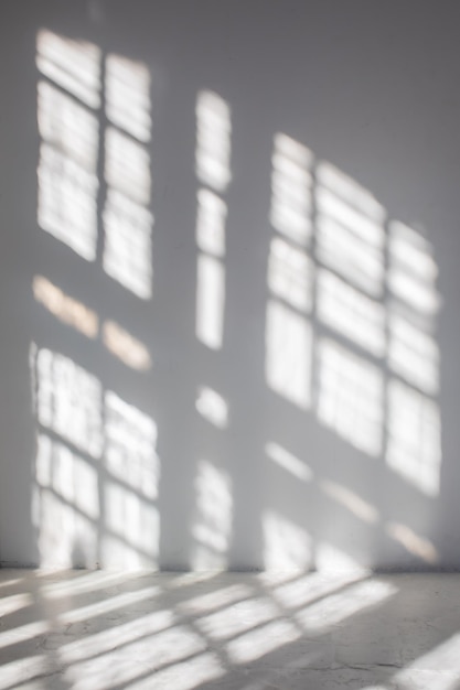 empty white wall where sunlight shining through a window concept of sunbeams to overlay a photo