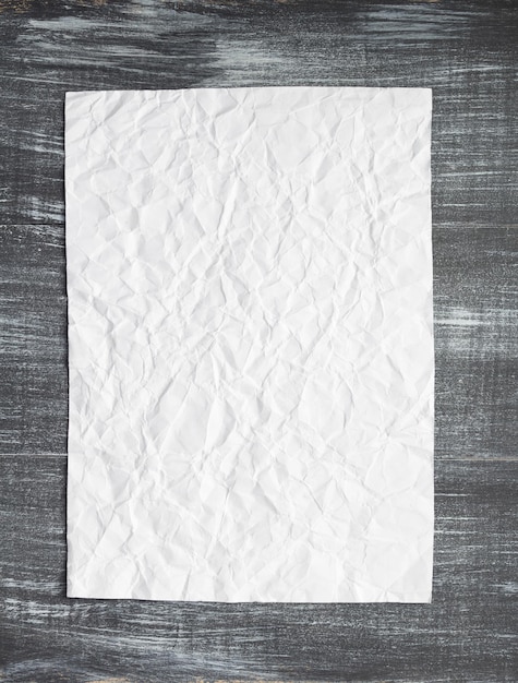 Empty white wrinkled paper at wood