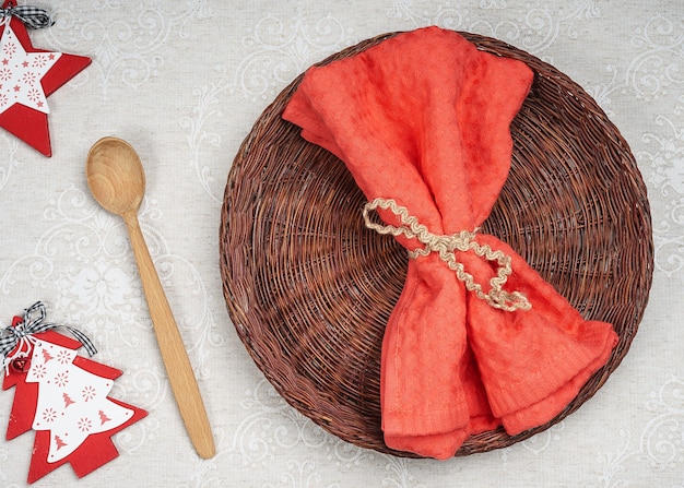 Foto piatto di vimini vuoto e cucchiaio di legno con decorazioni di natale e capodanno per il menu delle vacanze.