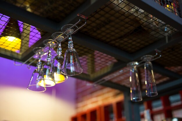 Empty wine or cocktail glasses hang on the bar in a bar or pub.