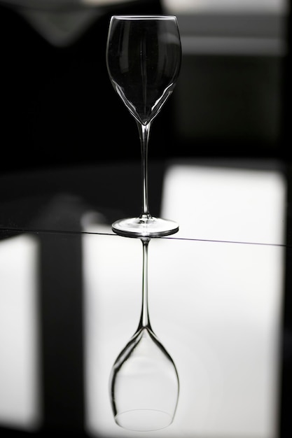 an empty wine glass stands on a glass table on a gray background empty wine glass