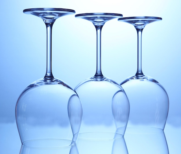 Foto bicchieri di vino vuoti disposti su sfondo blu
