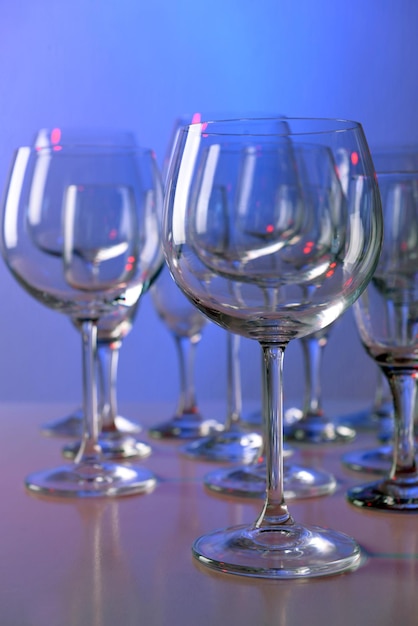 Empty wine glasses on color background