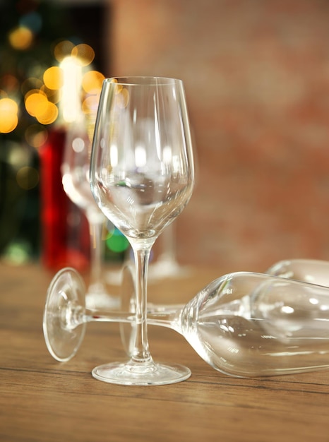 Empty wine glasses with bottle on wooden table against blurred background