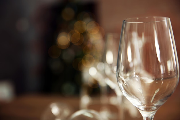 Empty wine glasses on wooden table against blurred background