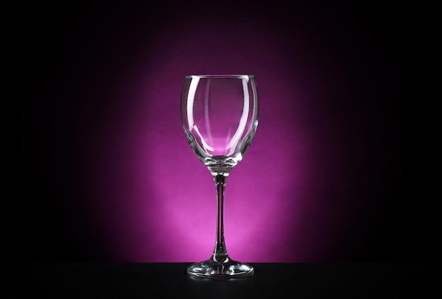 Empty wineglass on dark purple background