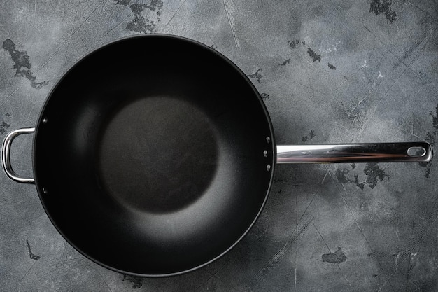 Padella wok vuota con spazio per la copia per testo o cibo con spazio per la copia per testo o cibo vista dall'alto piatto su sfondo grigio tavolo in pietra