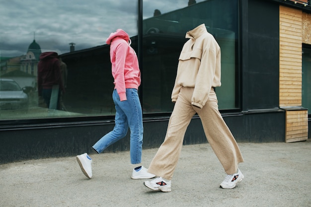 Empty woman clothes walk on street wearing hoody, jeans trousers, sneakers and colorful trainers.