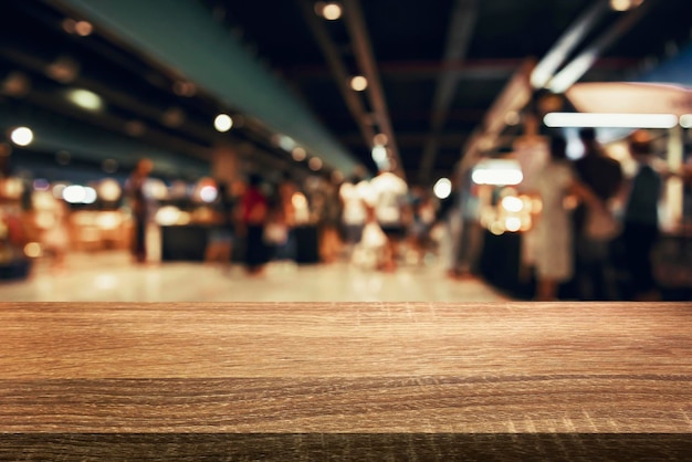 Legno vuoto su sfocatura bokeh chiaro del caffè in uno sfondo scuro