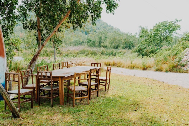 empty wood chair and table in garden - vintage effect filter