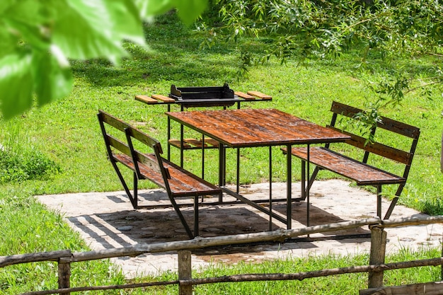 공공 공원의 푸른 초원에 있는 빈 나무 피크닉 테이블 초원의 피크닉 테이블