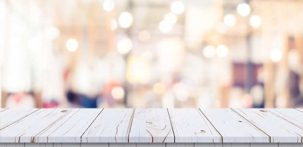 Empty wood table and blurred light table in shopping mall with bokeh background