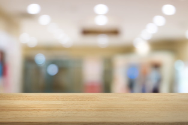 empty wood table over blurred shopping mall / department store background