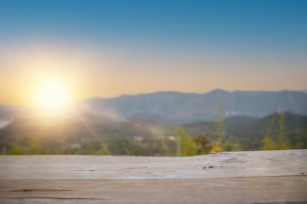 empty wood table for present product with soft blur natural forest with mountain background