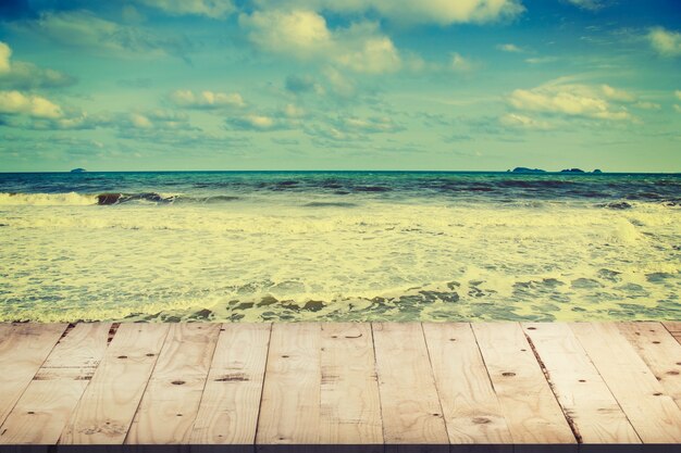 Tavolo in legno vuoto per la visualizzazione del prodotto e montaggio sulla spiaggia con annata tonica.