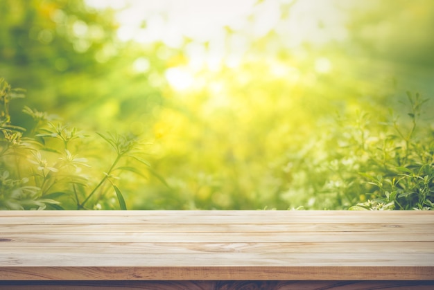 Empty of wood table top on blur of fresh green abstract from garden backgrounds