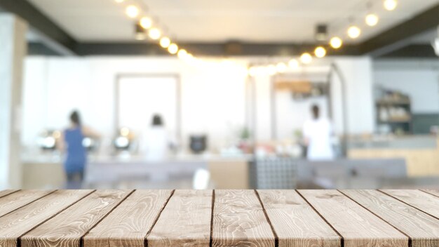 Empty wood table top and blurred coffee shop, cafe and restaurant interior